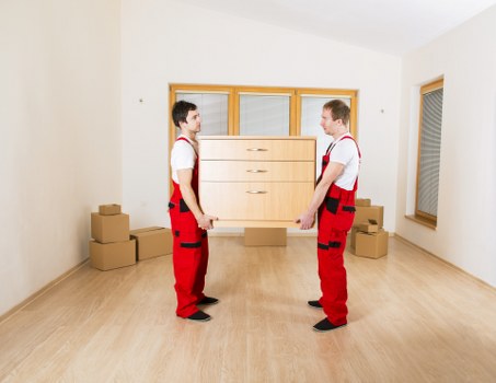 Professional movers carrying furniture through a Brompton property staircase